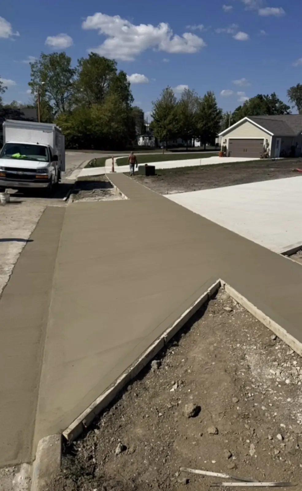 Fresh concrete driveway and sidewalk installation