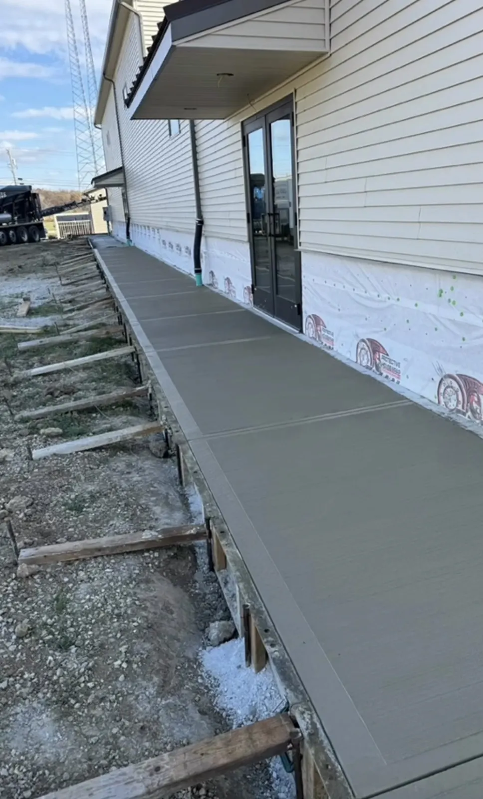 Freshly poured concrete sidewalk beside a home