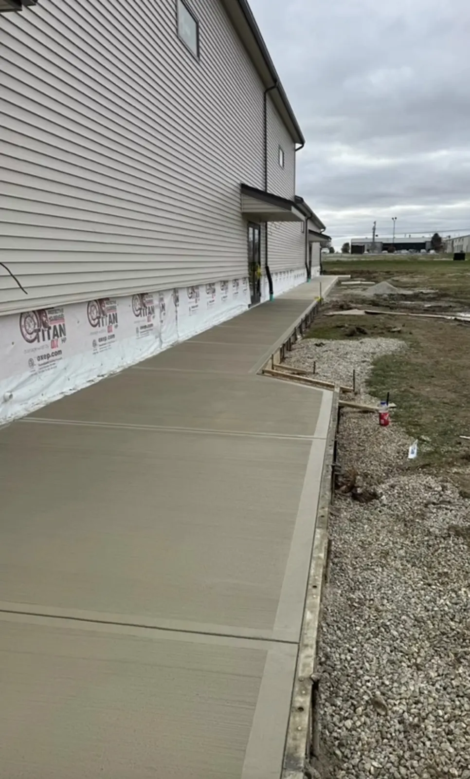 New concrete walkway installed along a building