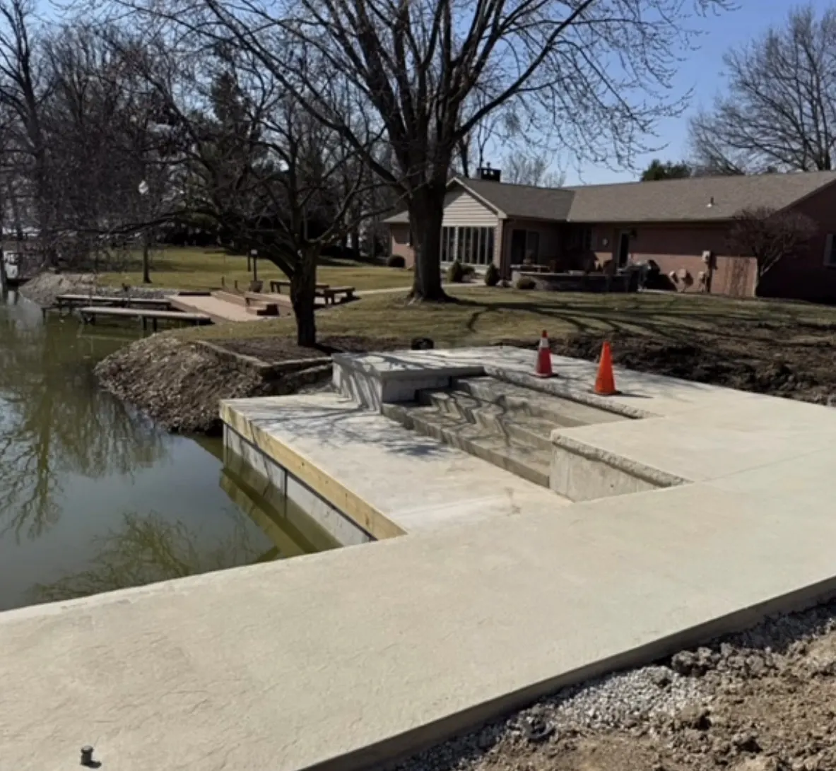 Concrete sidewalk and flatwork beside a pond