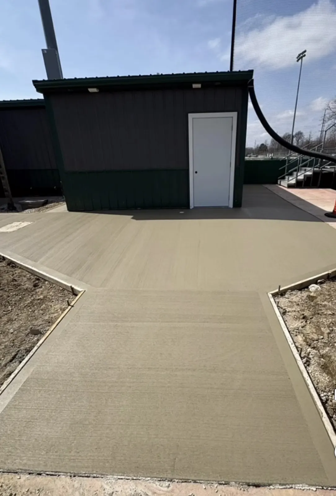 Finished concrete approach leading to a pole building